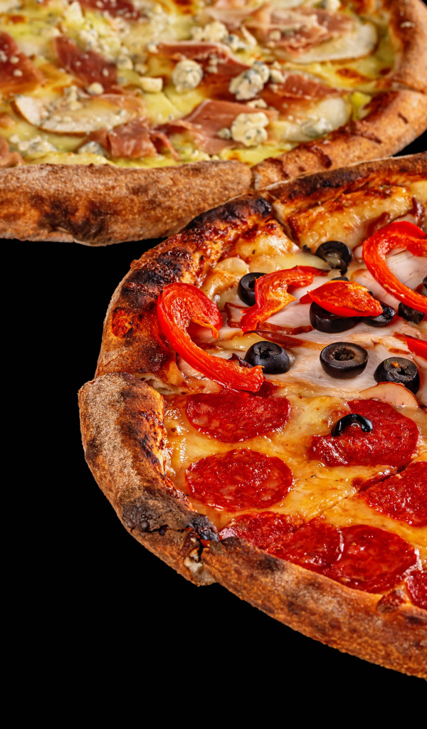 Две аппетитные пиццы на черном столе