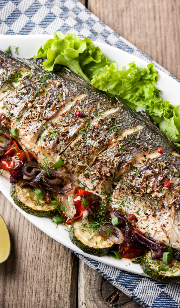 Большая запеченная рыба с кабачками и листьями салата