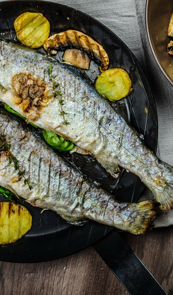 Две рыбины на сковороде с овощами