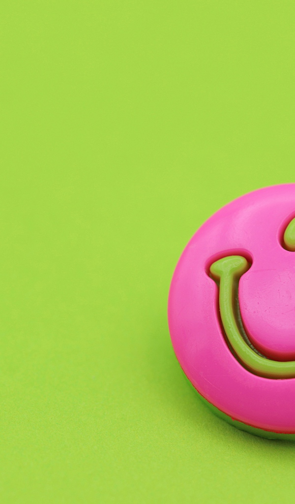 Розовый смайл на зеленом фоне