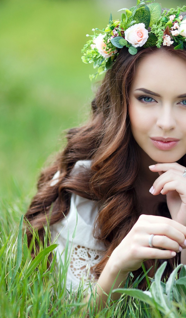 Девушка с красивыми длинными волосами лежит на траве