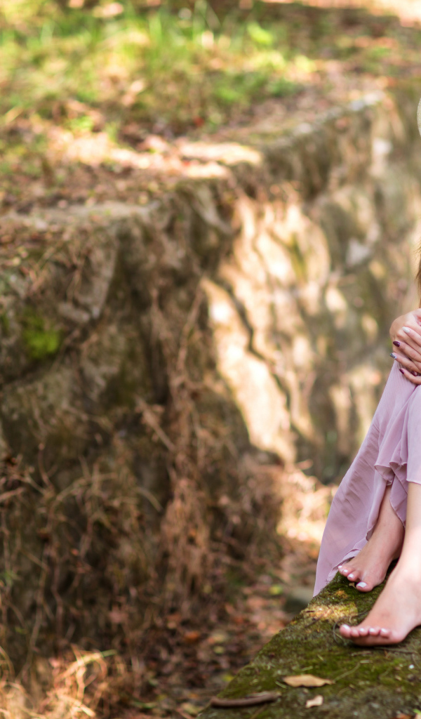 Девушка азиатка в розовом платье сидит на земле