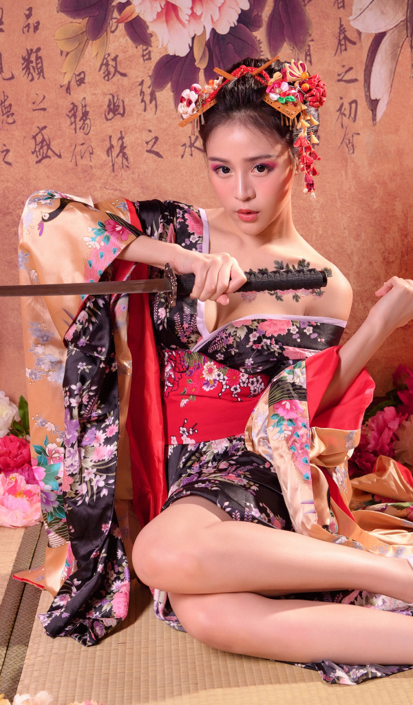 Девушка азиатка в кимоно с мечом сидит на полу 