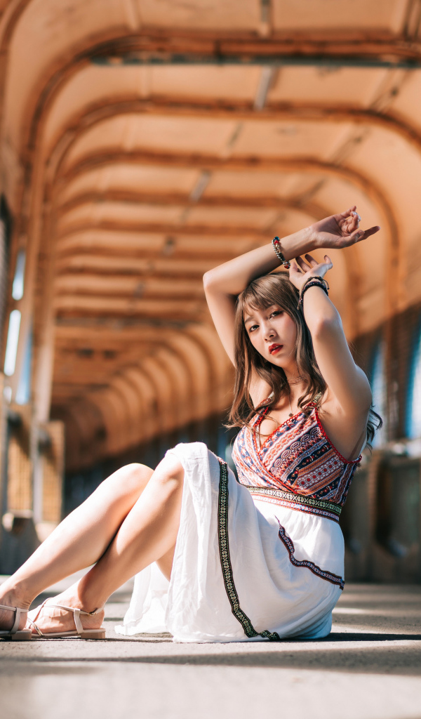 Девушка азиатка сидит в переходе 