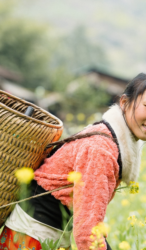 Девушка азиатка с корзиной на поле 