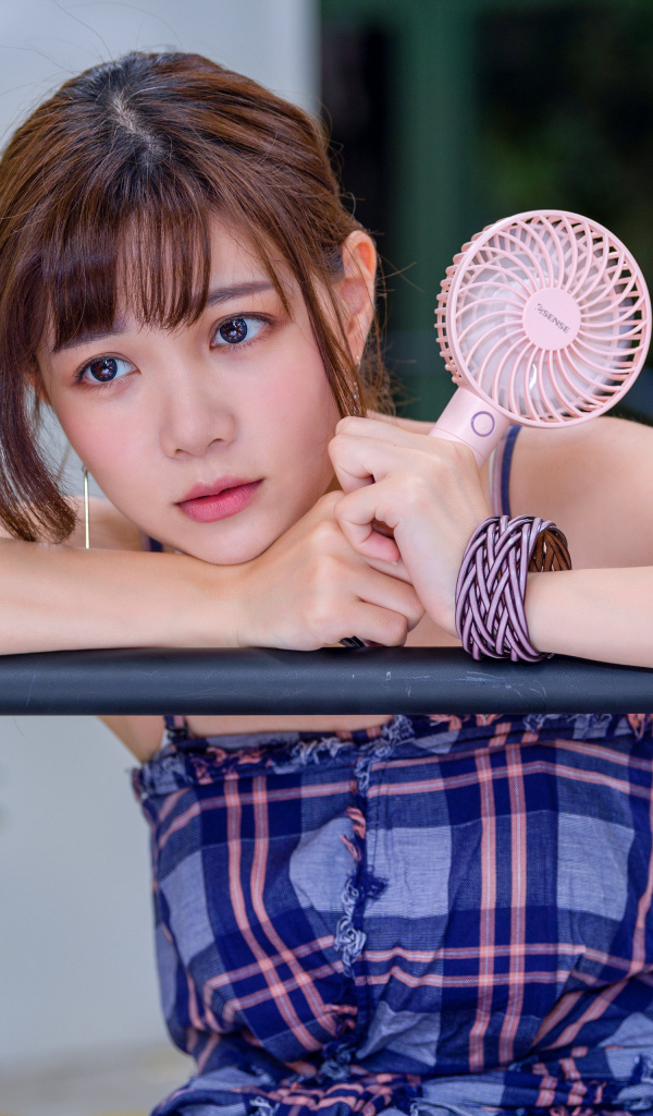 Девушка азиатка с вентилятором в руке 