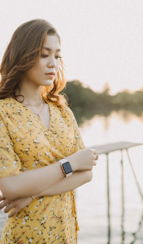 Красивая девушка азиатка стоит у реки 