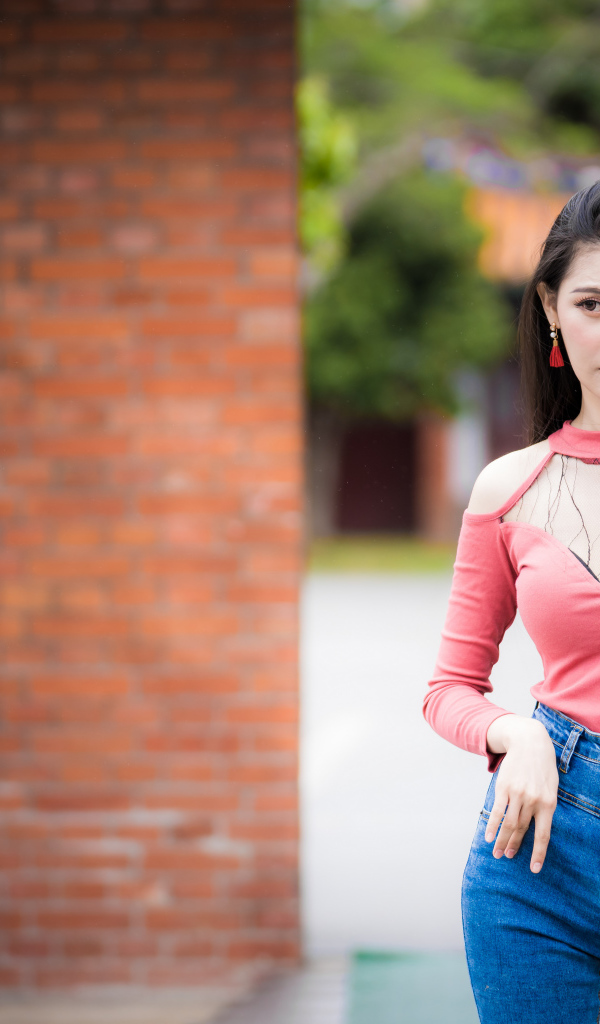 Красивая девушка азиатка в синих джинсах 