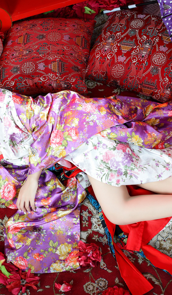 Красивая девушка азиатка в кимоно лежит на полу