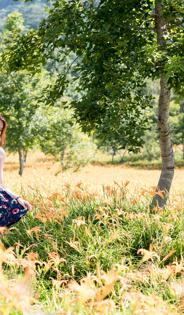 Красивая азиатка гуляет по высокой траве