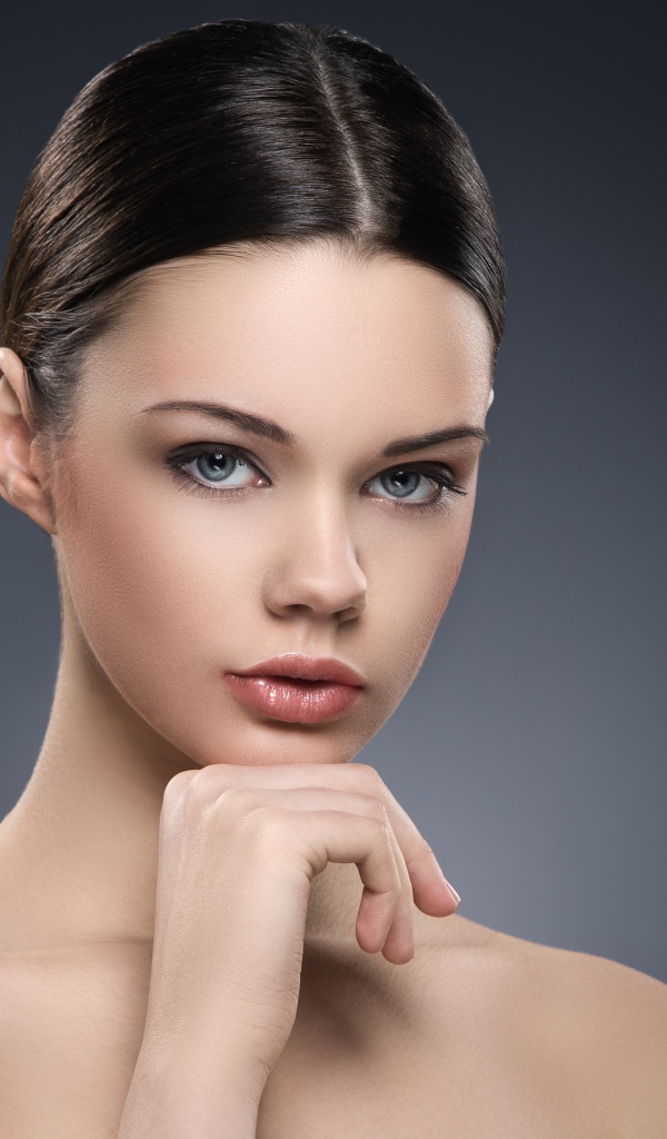 Красивая голубоглазая девушка на сером фоне 