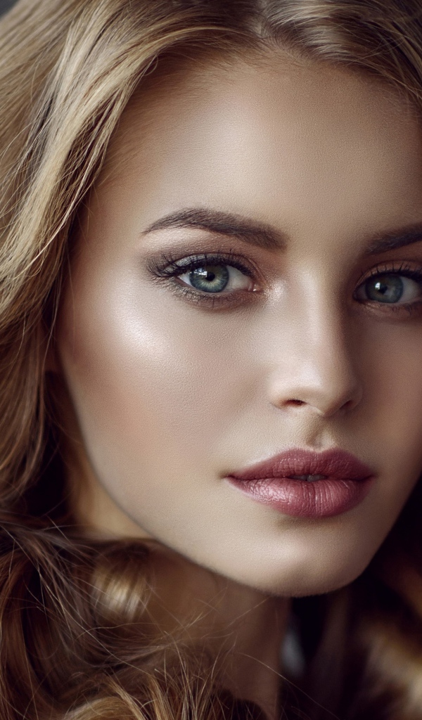 Красивые голубые глаза молодой длинноволосой  девушки