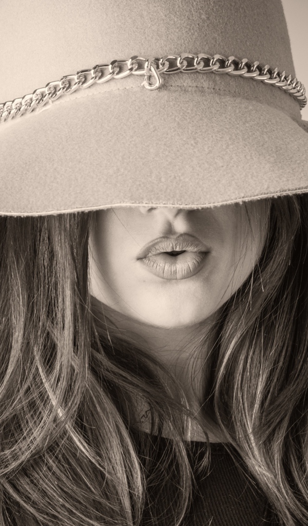 Красивая девушка закрыла лицо шляпой 