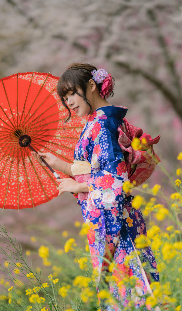 Красивая девушка в кимоно с зонтом в руке 