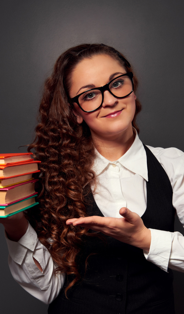 Красивая девушка учитель в очках с книгами в руке