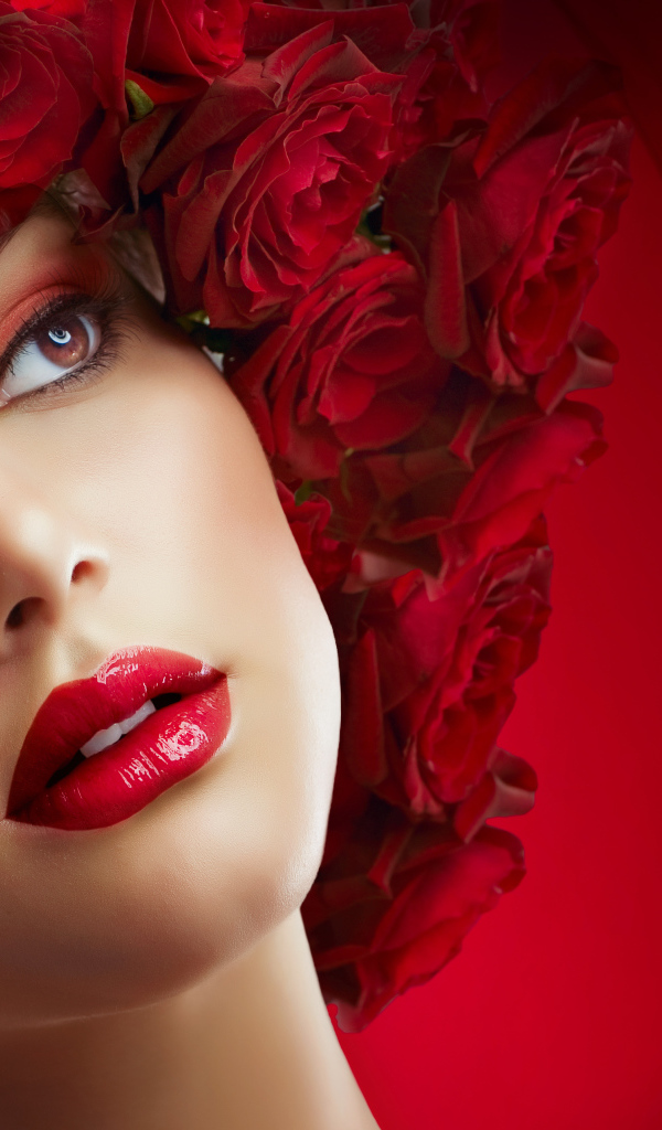 Красивая девушка с венком из роз на голове на красном фоне