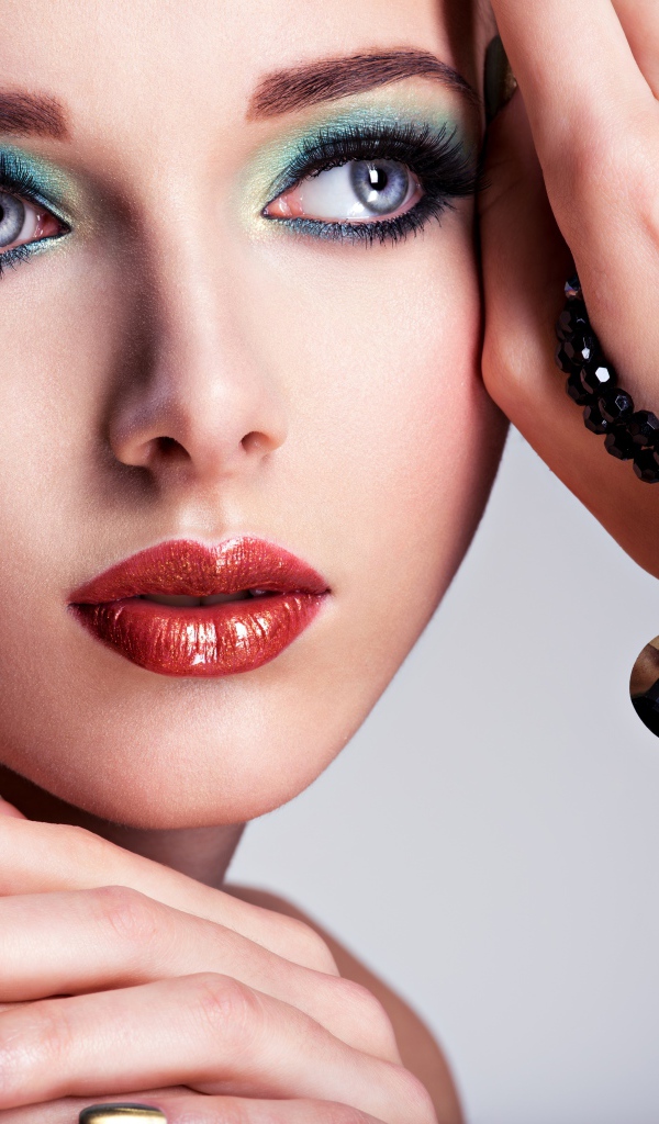 Красивая девушка с ярким макияжем с украшением на руке