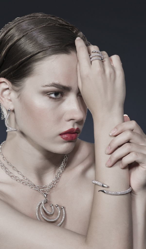 Красивая девушка с украшениями на теле на сером фоне