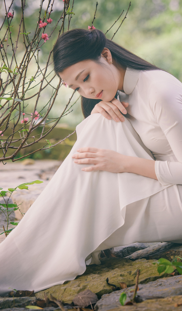 Красивая грустная девушка азиатка в белом платье 