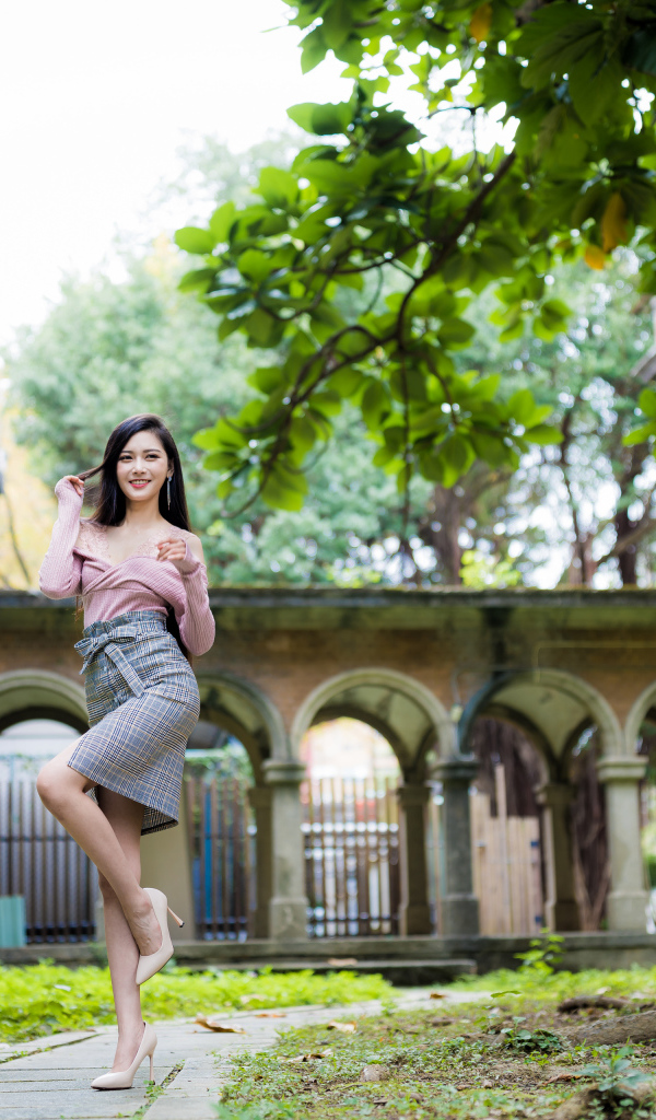 Красивая стройная азиатка на фоне здания