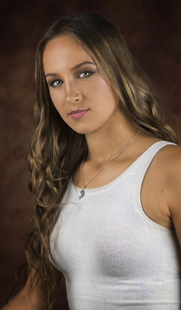 Красивая молодая девушка с длинными волосами в белой майке 