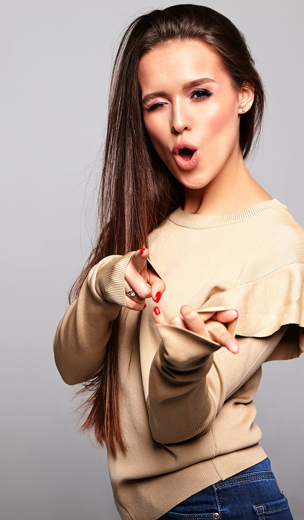 Яркая длинноволосая девушка на сером фоне 