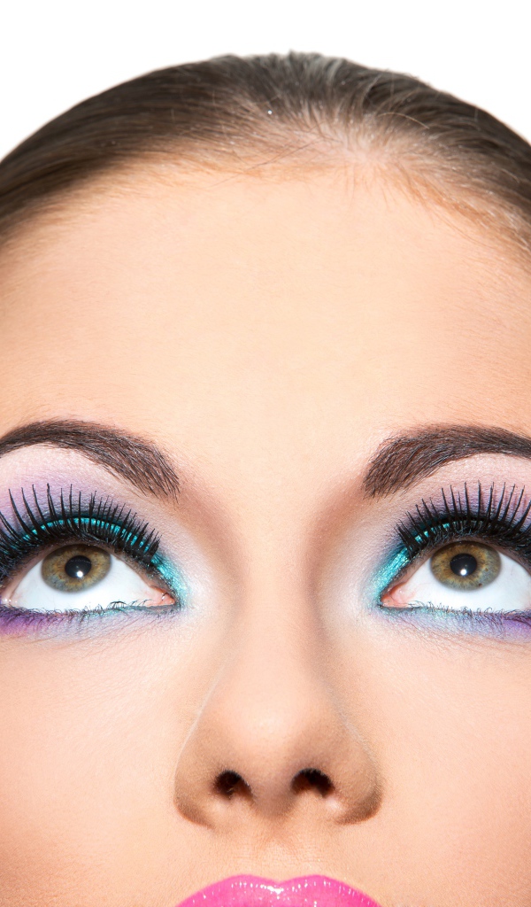 Яркий макияж на глазах у девушки на белом фоне