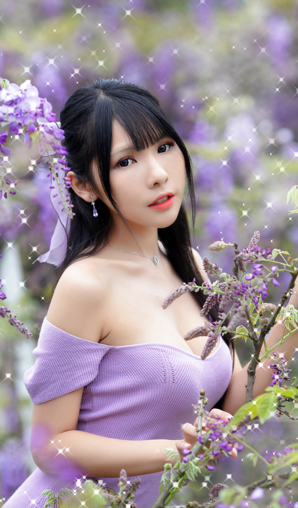 Кареглазая азиатка у куста с цветами глицинии