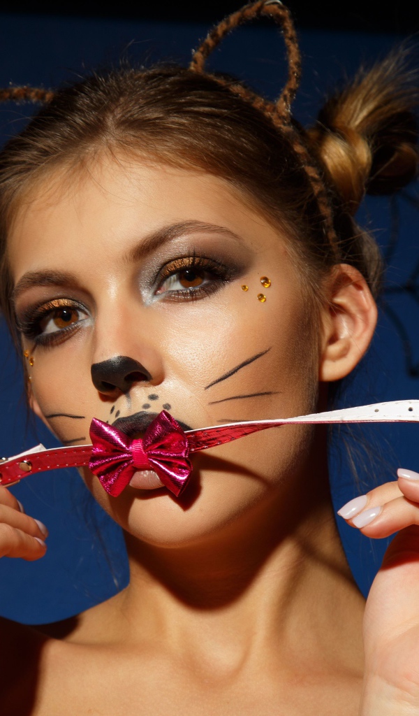 Девушка кошка с красным бантиком во рту 