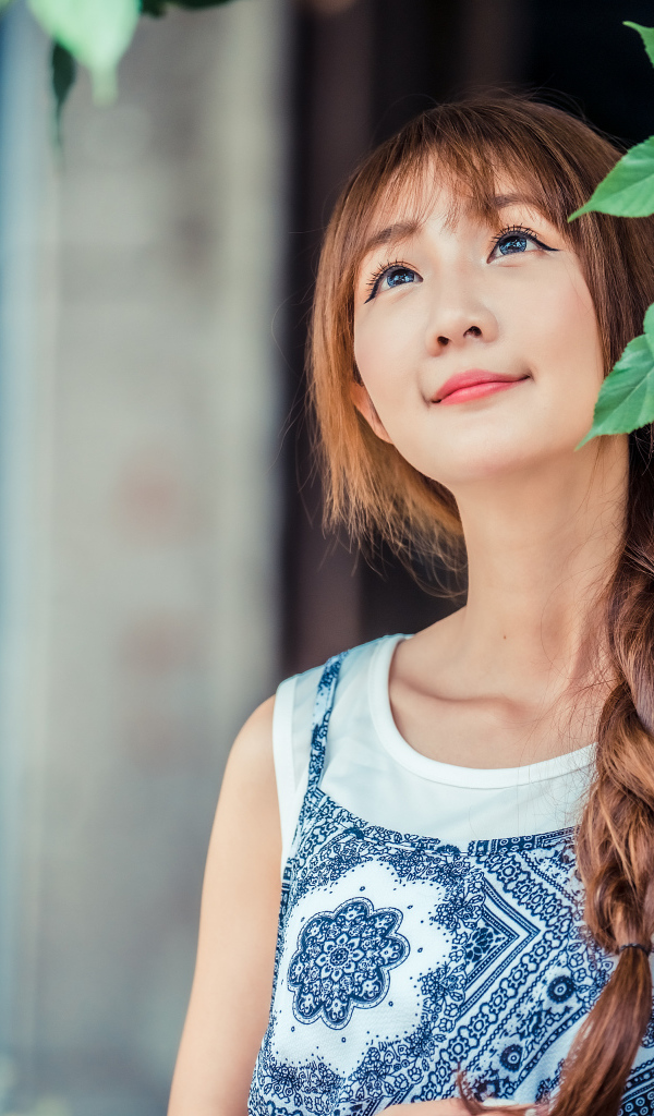 Милая девушка азиатка с косой на голове