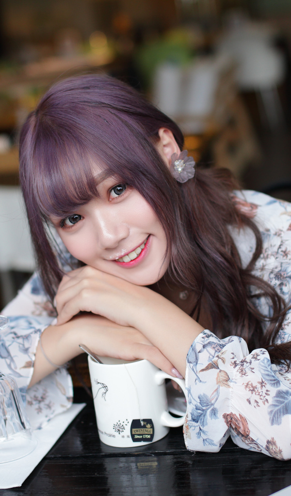 Милая девушка азиатка сидит за столиком