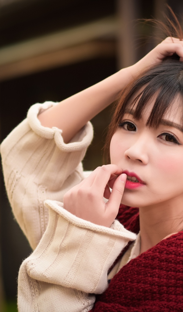 Милая девушка азиатка с рукой в волосах 