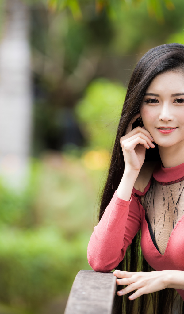 Милая улыбающаяся девушка азиатка розовой кофте