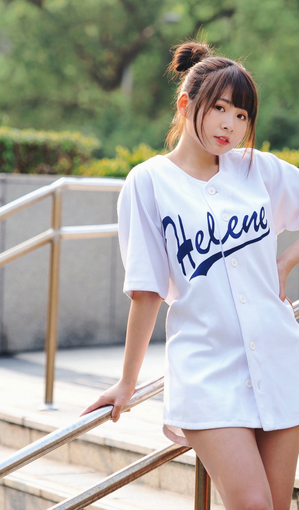 Симпатичная молодая азиатка стоит у перил