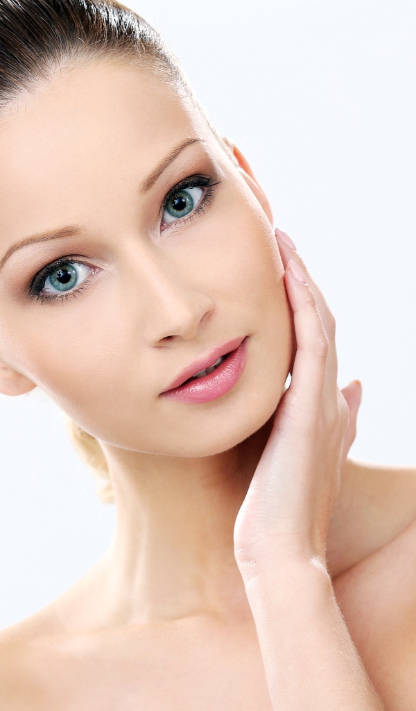 Нежная голубоглазая девушка без макияжа на белом фоне