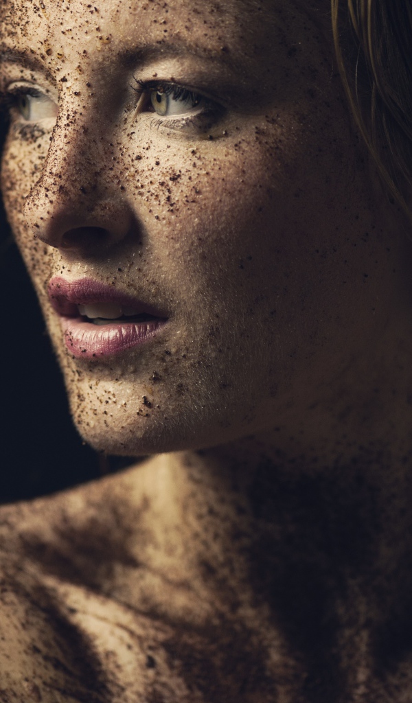 Грязная девушка в земле на черном фоне