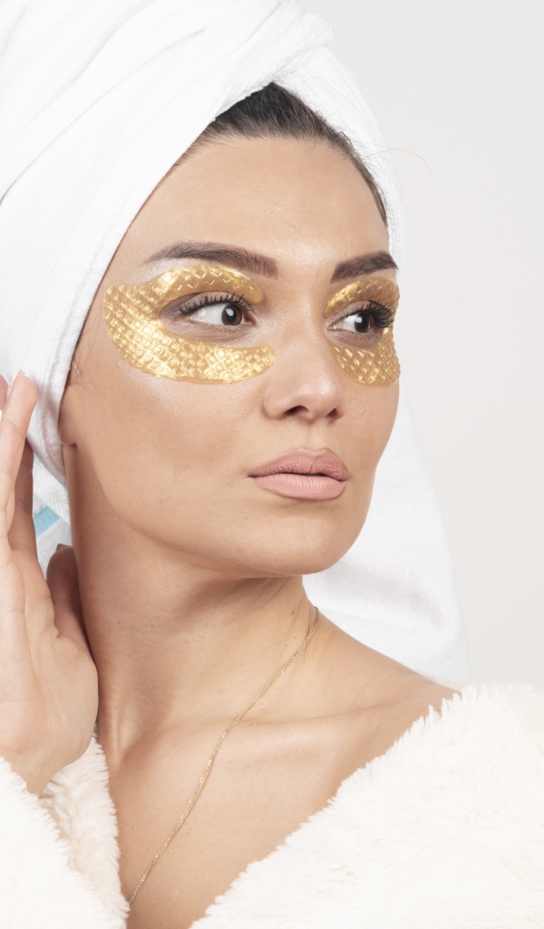 Девушка после душа с золотыми патчами под глазами