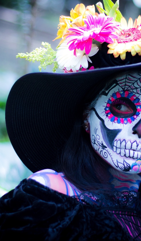 Девушка с маской на лице в черной шляпе