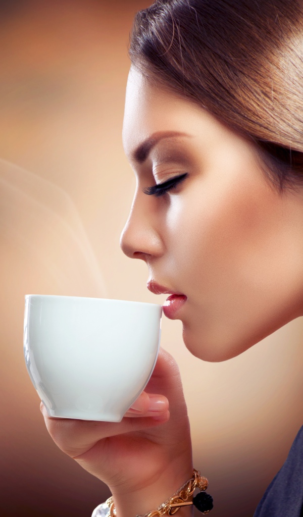 Девушка с закрытыми глазами наслаждается кофе