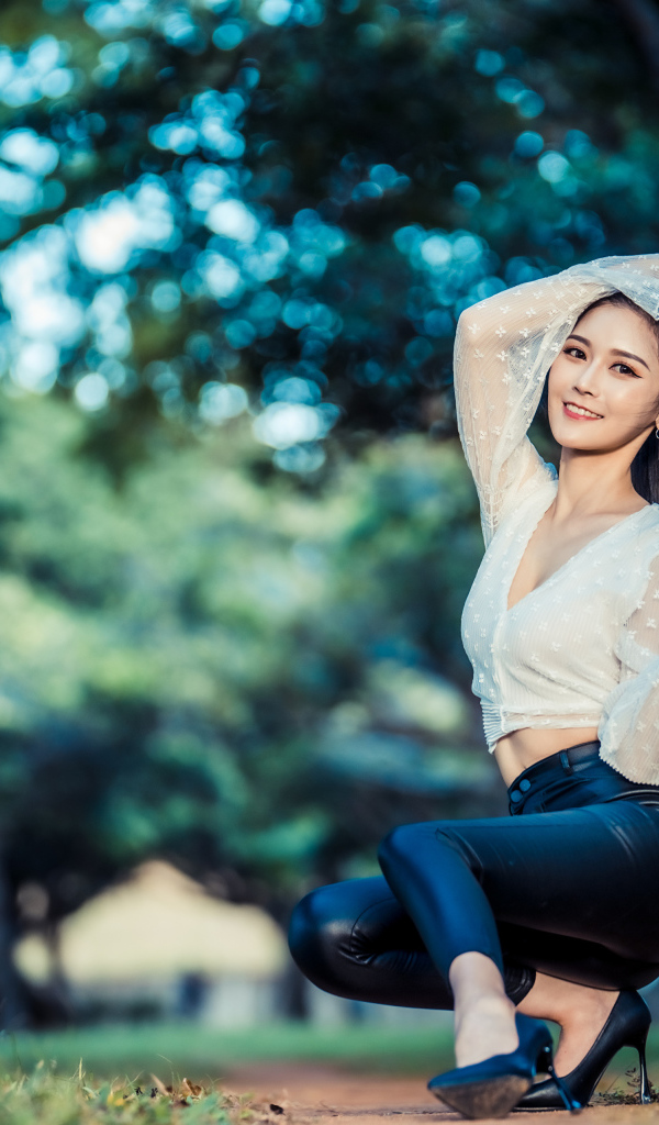 Улыбающаяся азиатка в черных брюках