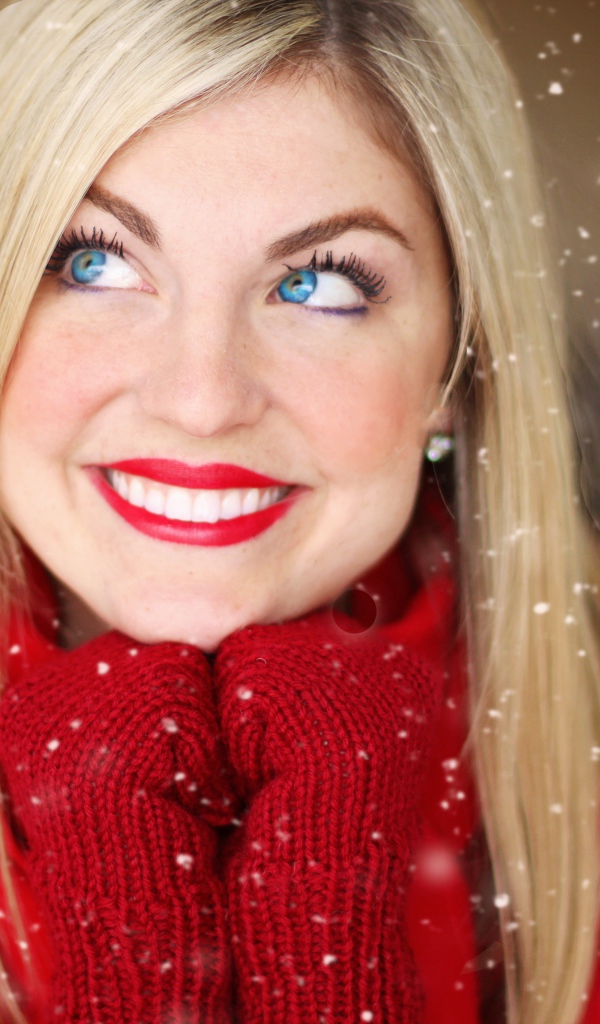 Улыбающаяся голубоглазая девушка в красном свитере 