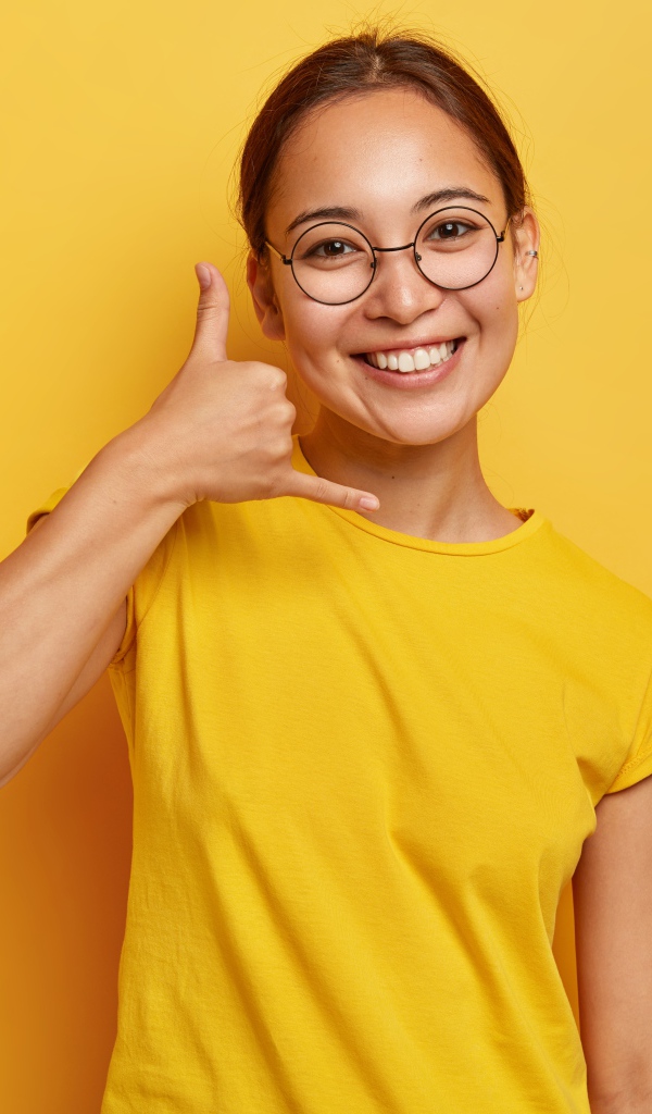 Улыбающаяся девушка на желтом фоне 