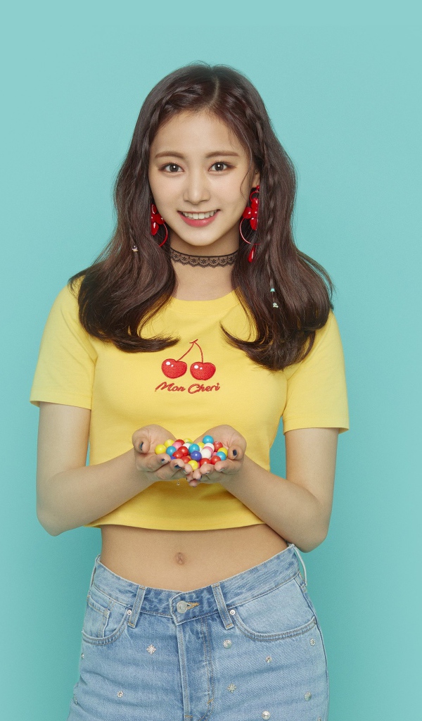 Улыбающаяся девушка с конфетами в ладонях на голубом фоне 