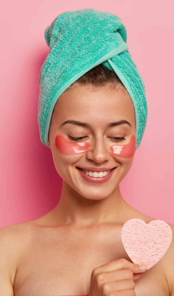 Улыбающаяся девушка с полотенцем на голове после душа