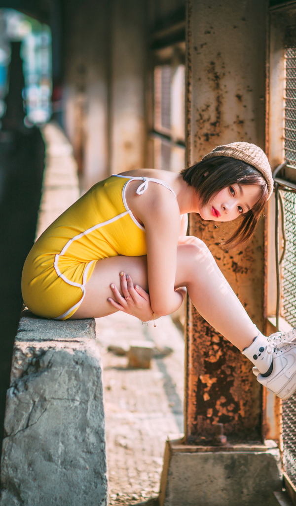 Молодая девушка азиатка сидит у сетки