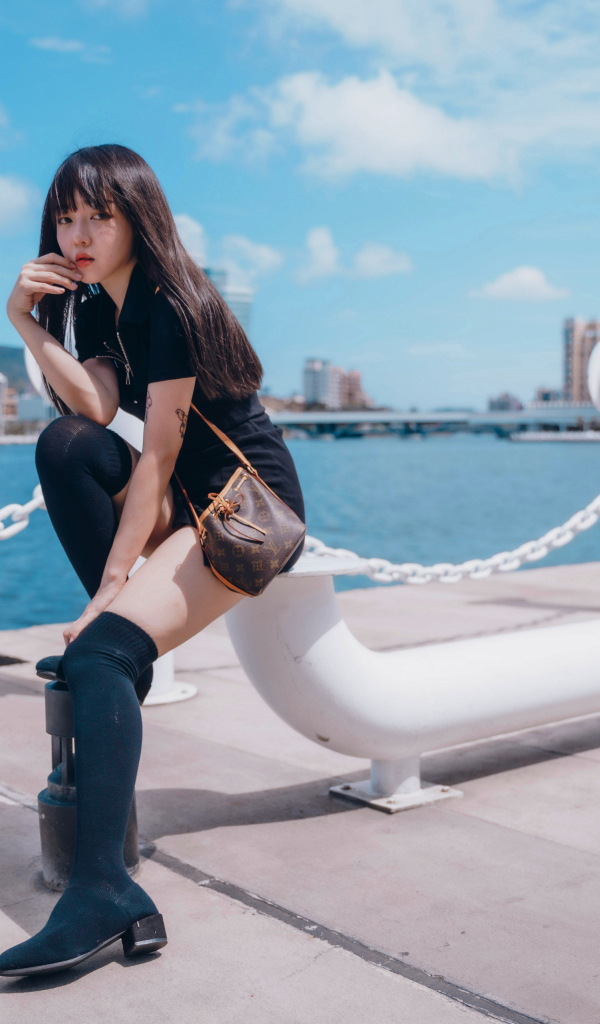 Молодая азиатка сидит в порту 