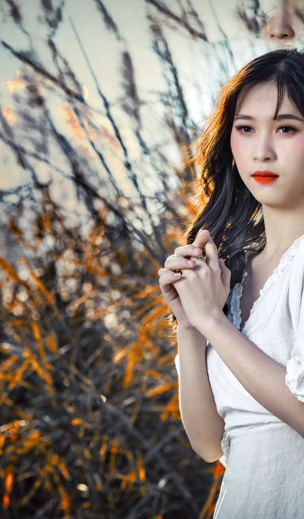 Молодая девушка азиатка в белом платье на закате