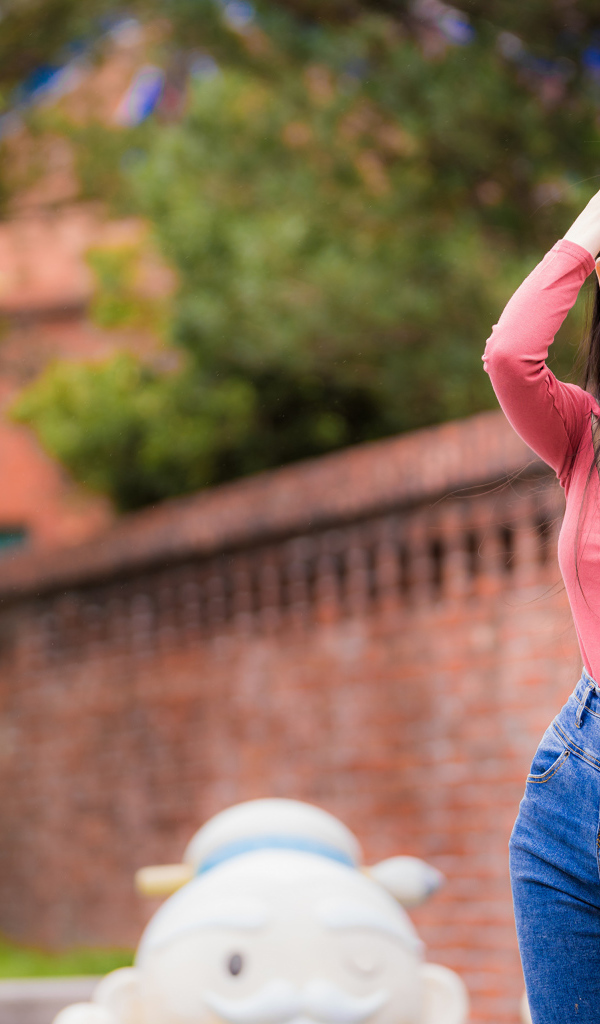 Молодая стройная азиатка в джинсах 