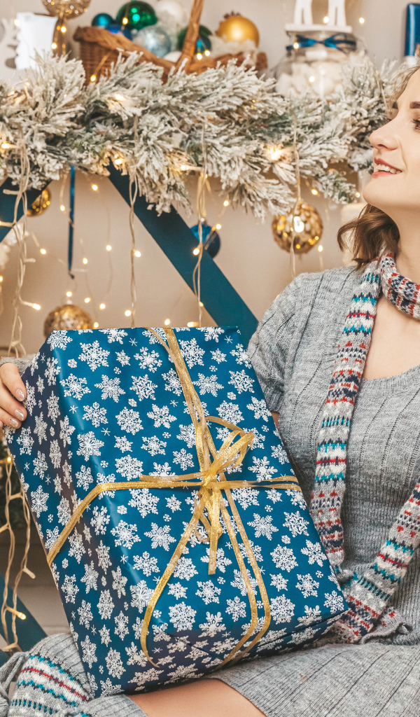 Красивая девушка с большим подарком на Рождество