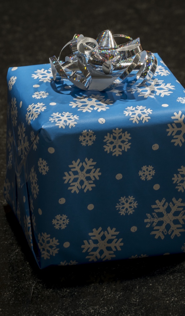 Большой голубой подарок с бантом на черном фоне 